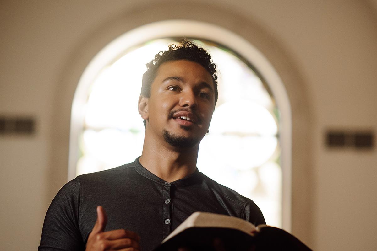 a PBA student holding a Bible while standing in 的 chapel